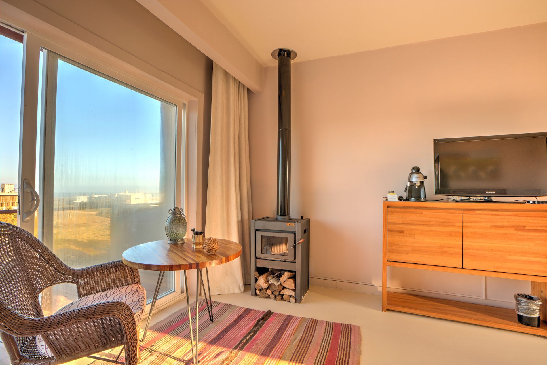 Una sala de estar con chimenea, silla, mesa y televisión.