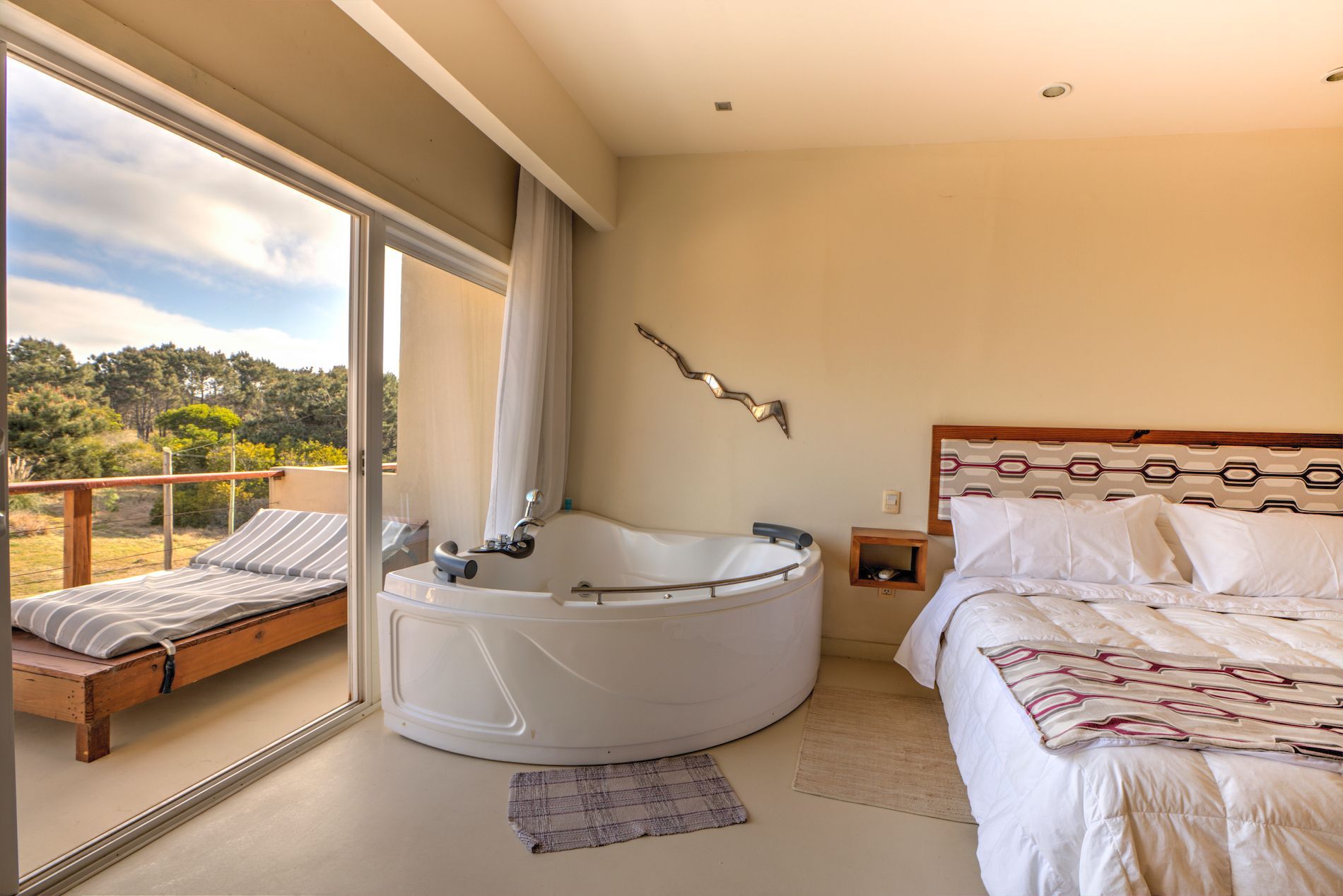 Un dormitorio con una gran bañera en el medio.