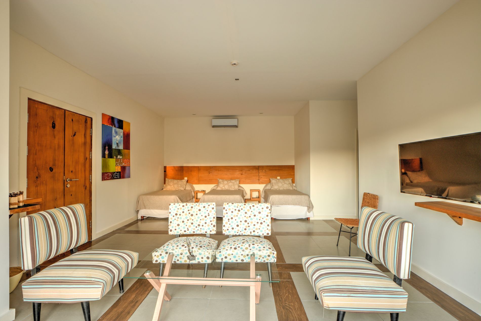 Una sala de estar con una mesa, sillas y dos camas.