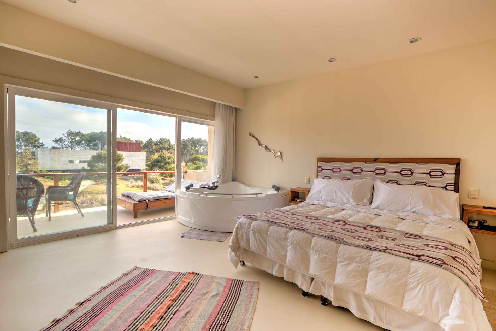 Un dormitorio con una cama grande y una bañera de hidromasaje.