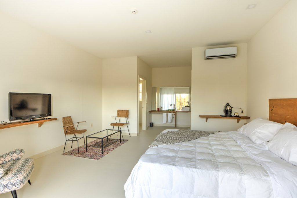 Un dormitorio con una cama tamaño king y un televisor de pantalla plana.