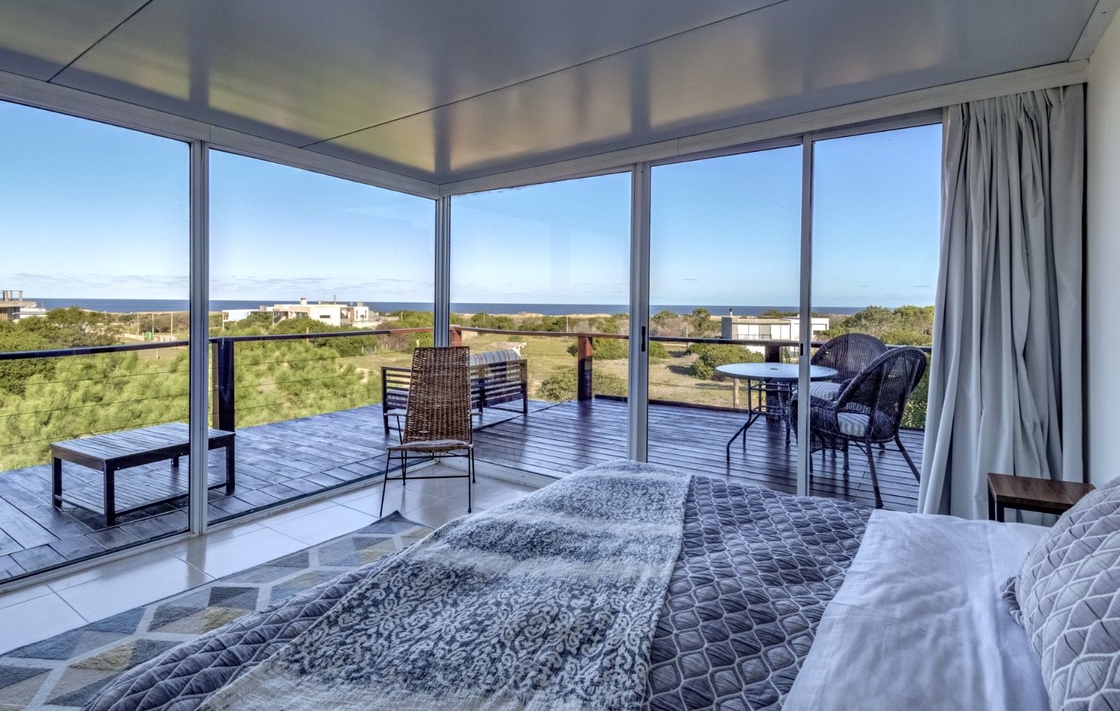 Un dormitorio con una cama grande y un balcón con vista al mar.