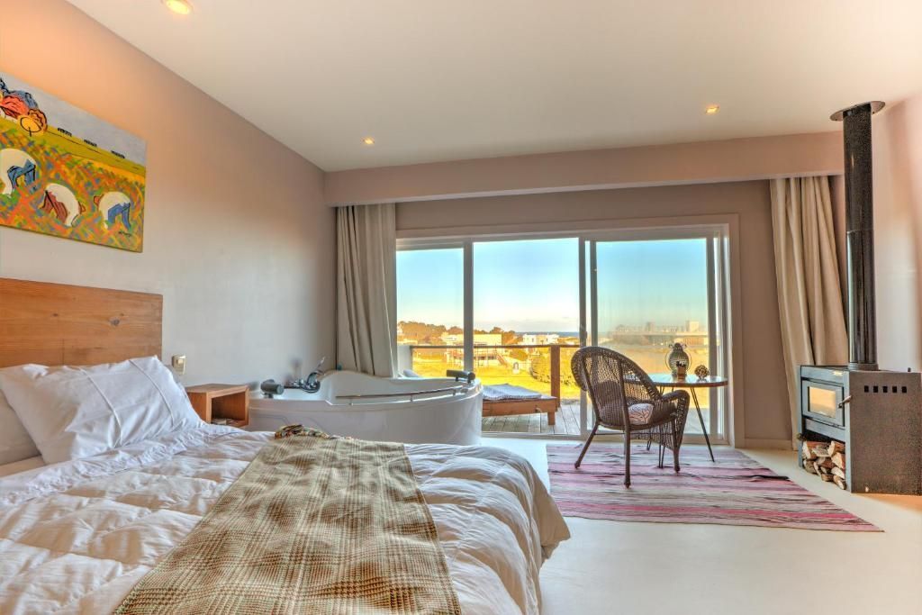 Una habitación de hotel con una cama grande y una bañera de hidromasaje.