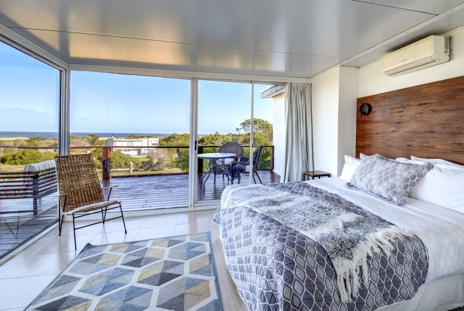 Hay una cama grande en el medio de la habitación con vista al océano.