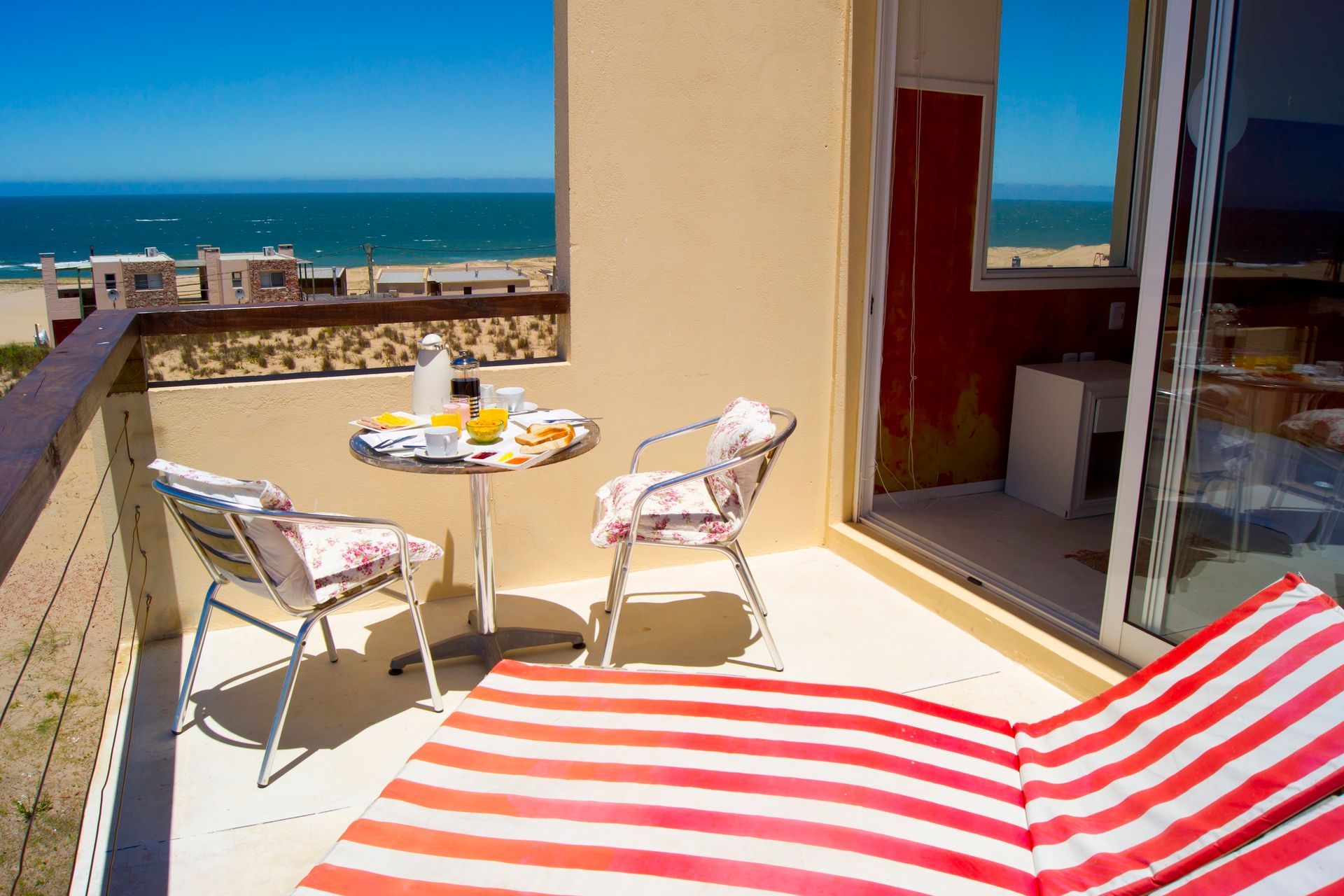 Un balcón con mesa y sillas con vista al mar.