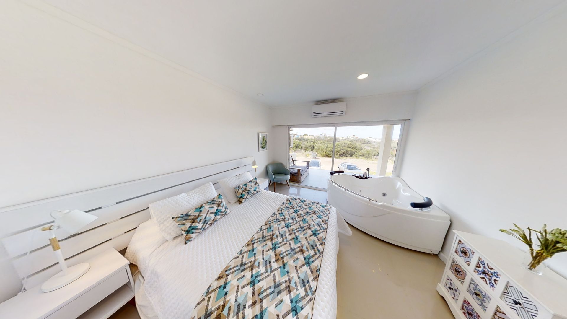 Un dormitorio con una cama king size y una bañera de hidromasaje.