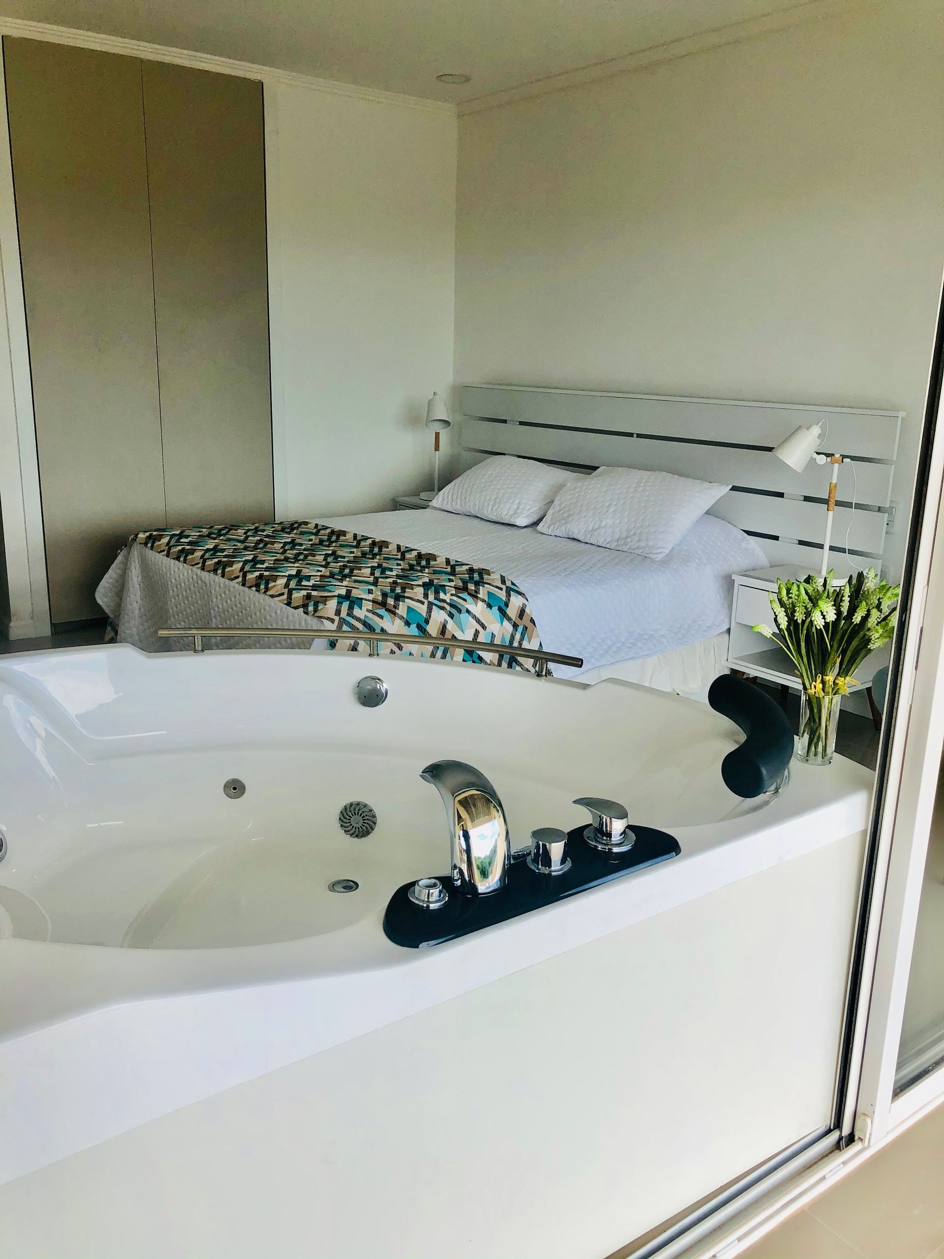 Un dormitorio con bañera de hidromasaje y una cama.