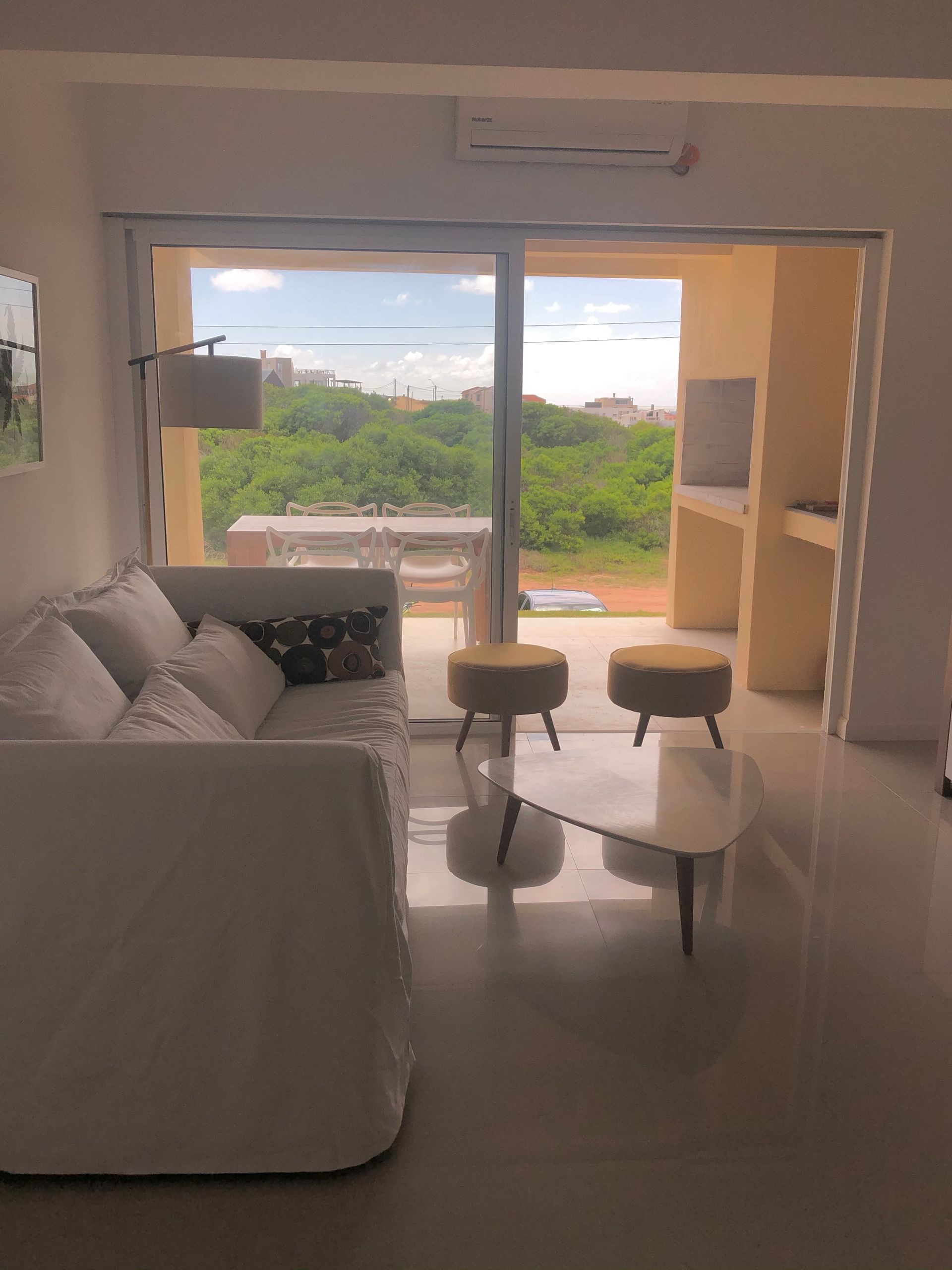 Una sala de estar con un sofá blanco y una mesa de café blanca.