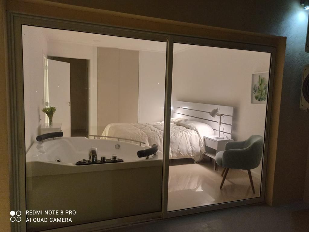 Un dormitorio con una puerta corrediza de vidrio y una bañera de hidromasaje.