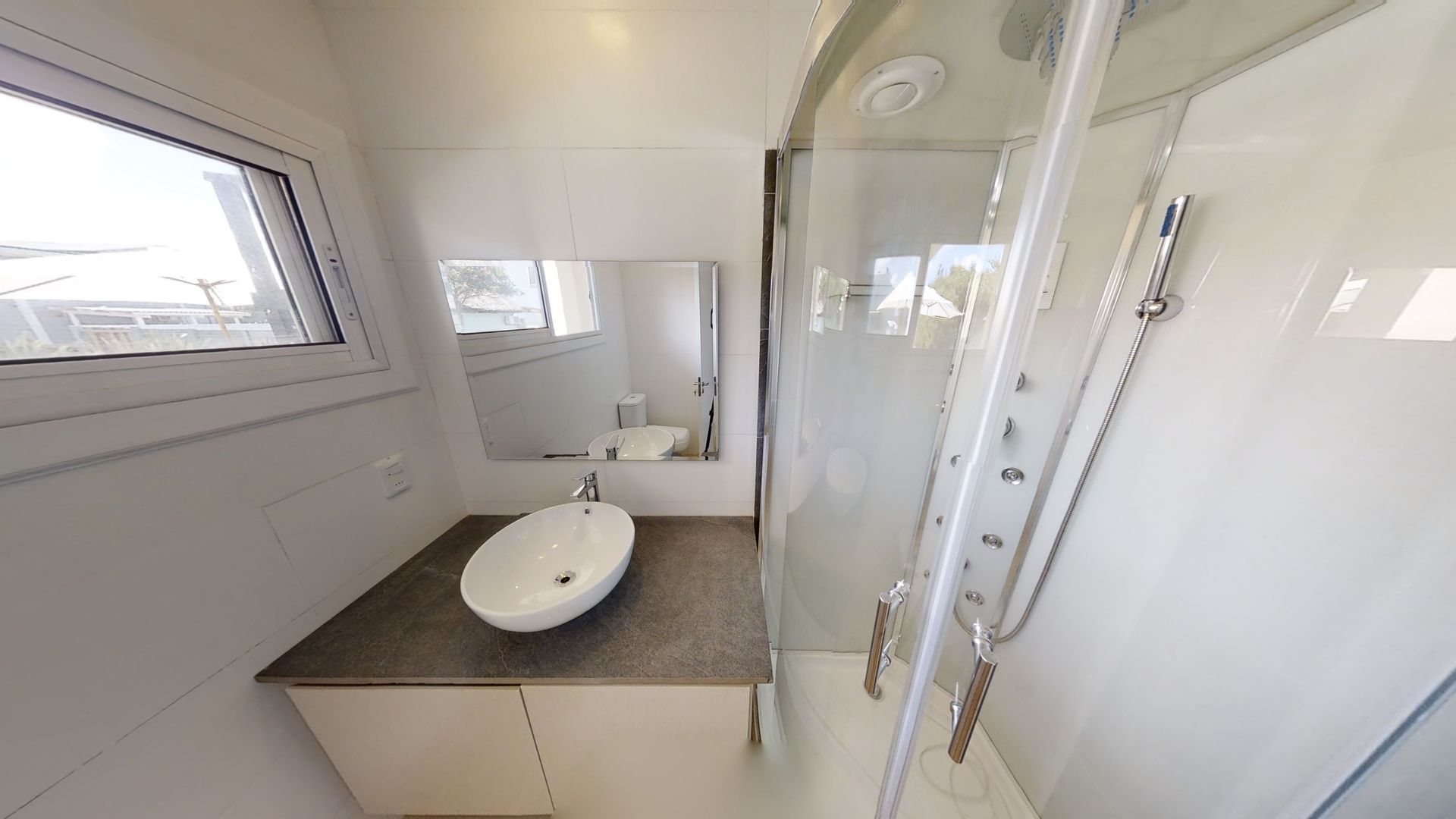 Un baño con lavabo, espejo y ducha.