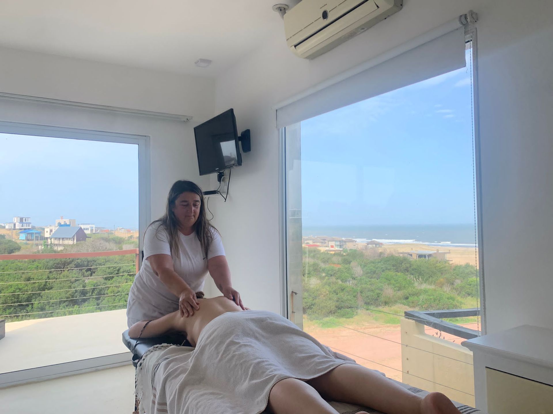 Una mujer le está dando un masaje a una mujer acostada en una mesa.