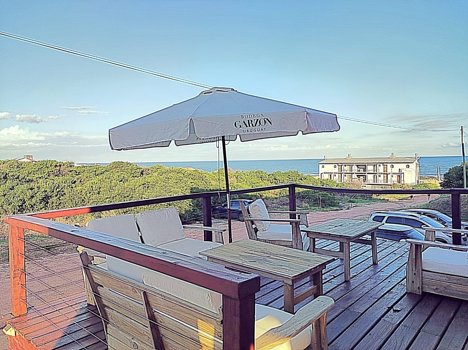 Hay una sombrilla en la terraza con vista al océano.