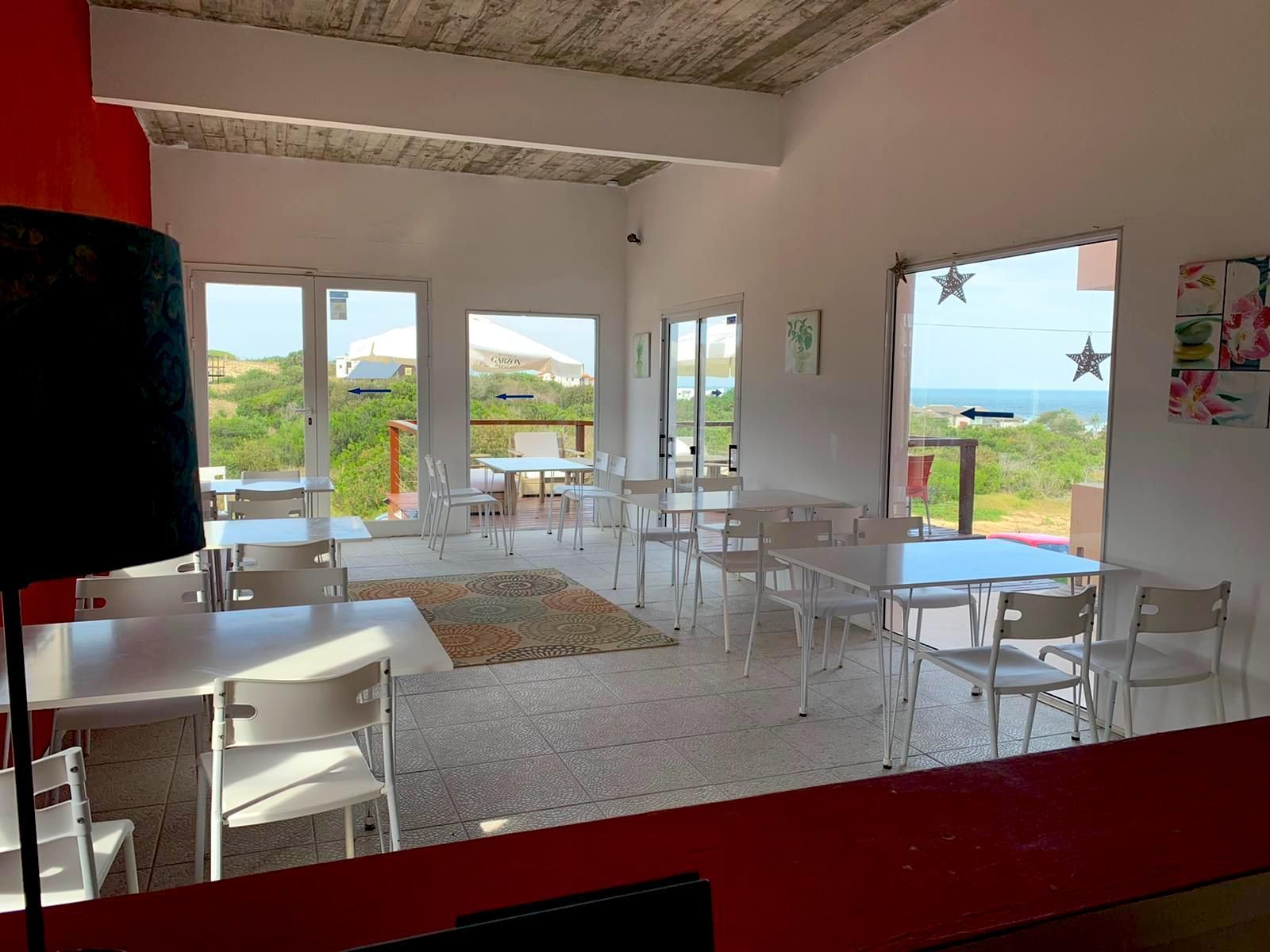 Un restaurante con mesas y sillas y vista al mar.