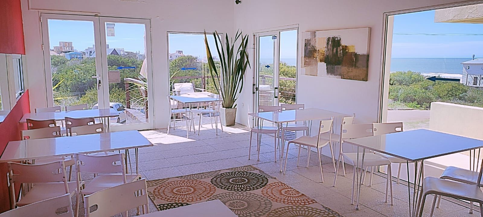 Una habitación con mesas y sillas y vista al mar.