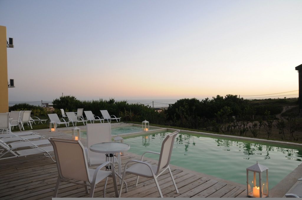 Una piscina con mesas y sillas alrededor.