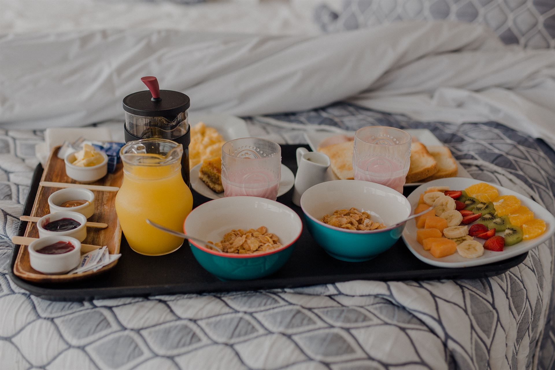 Una bandeja de comida está encima de una cama.