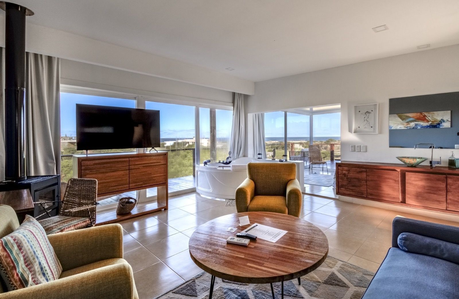 Una sala de estar con un sofá, sillas, una mesa y un televisor de pantalla plana.