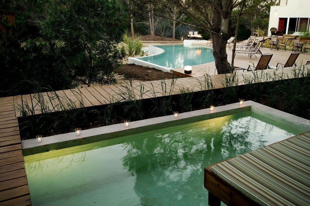 Una gran piscina rodeada de sillas y árboles.