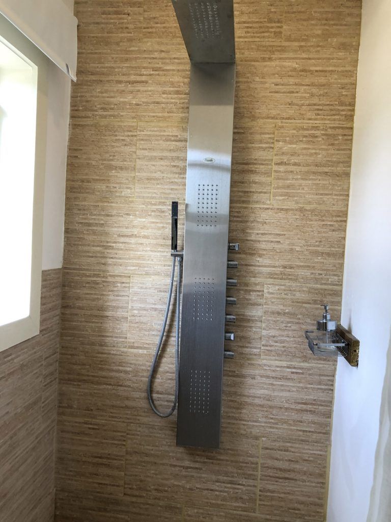 Una ducha con cabezal de ducha de acero inoxidable y ventana.