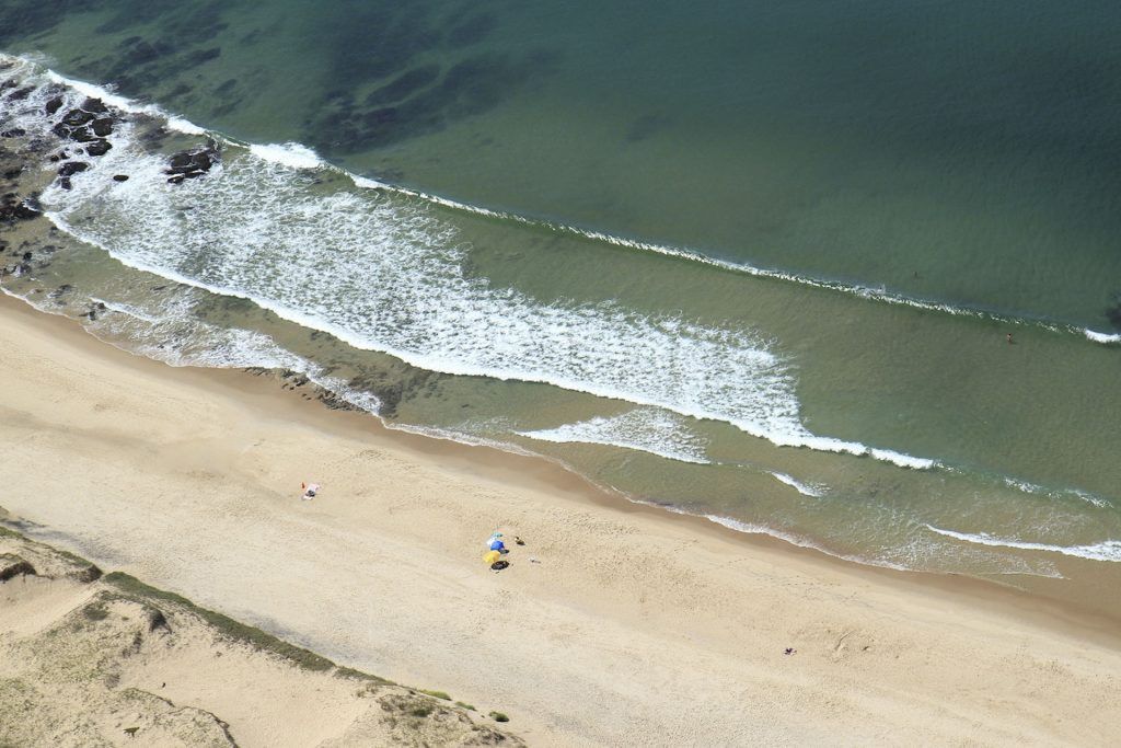 Una vista aérea de una playa con olas rompiendo en la orilla.