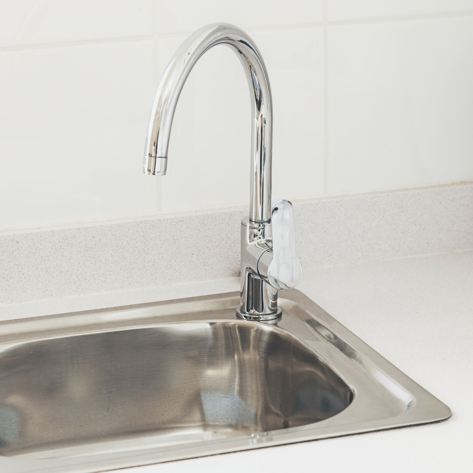 A man is fixing a faucet in a kitchen