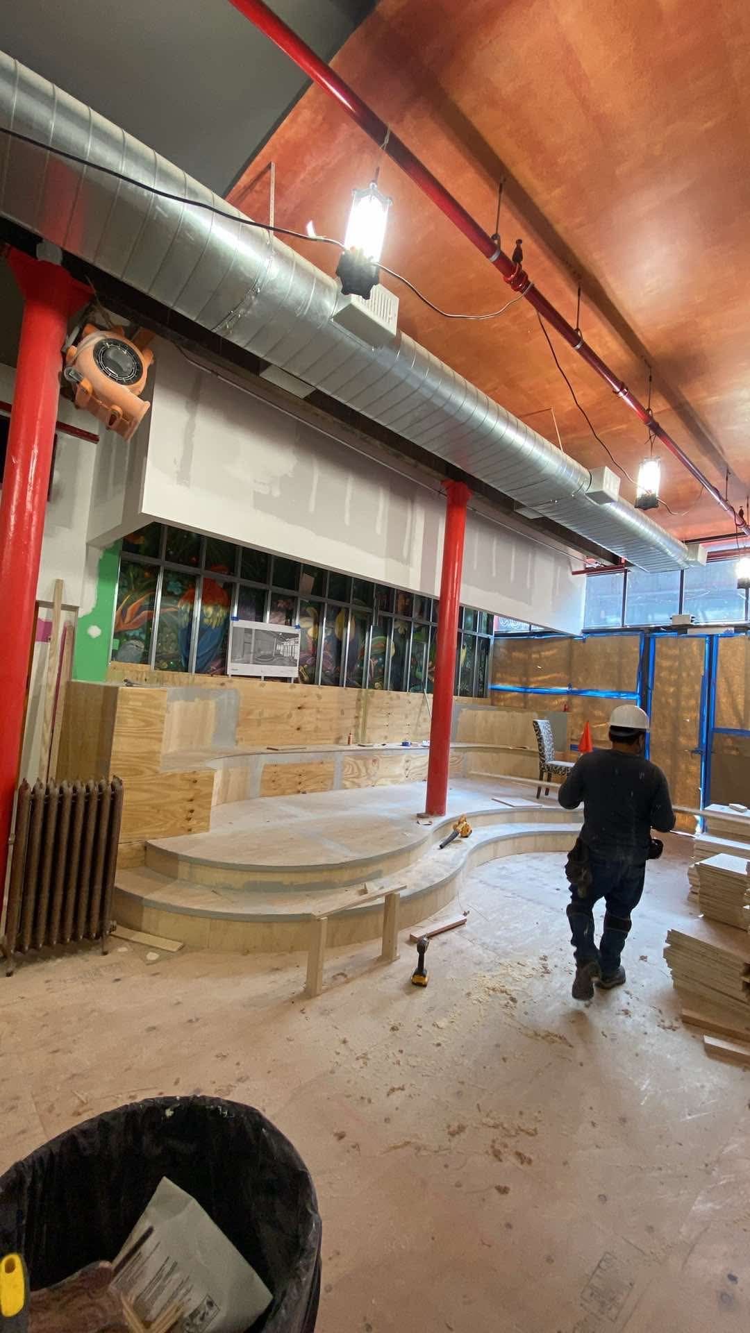 A man is walking through a building under construction.