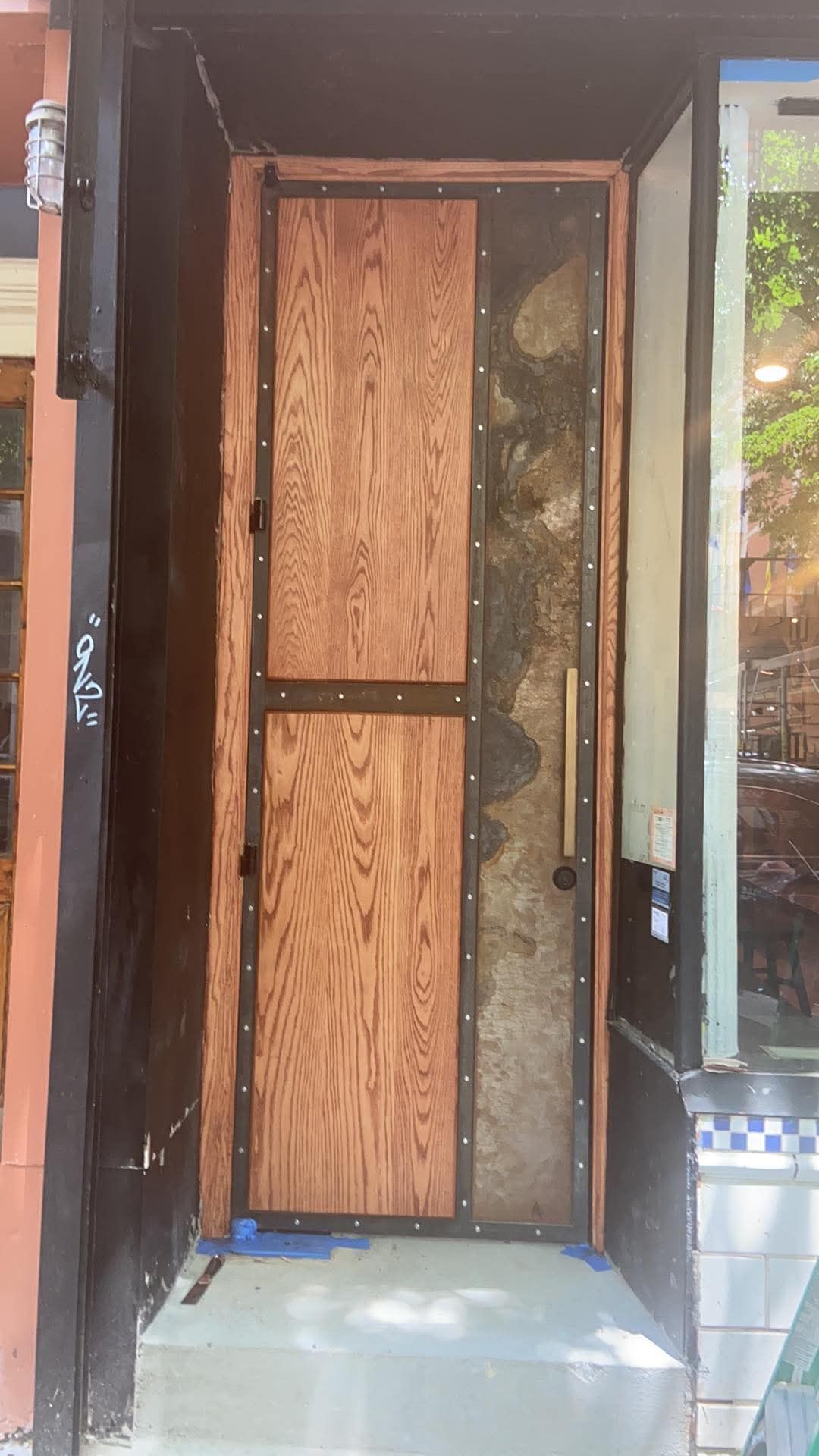 A wooden door is being installed on the side of a building.