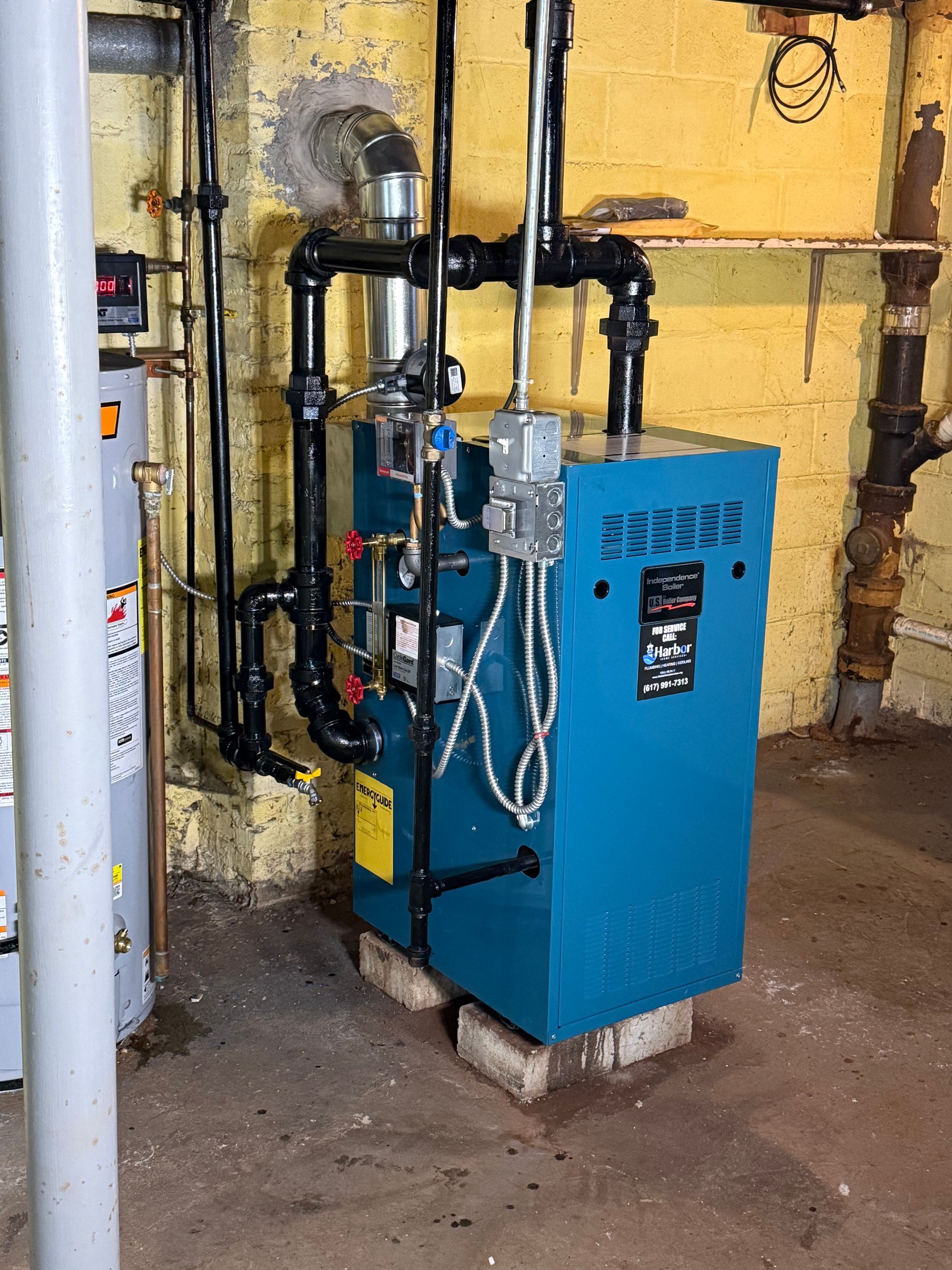 Blue boiler in a basement, pipes and ductwork visible.