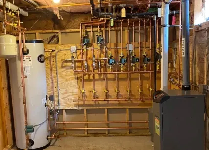 Plumbing system with copper pipes, a water heater, and a boiler in a utility room.