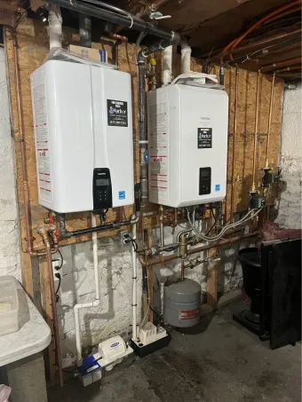 White air conditioner unit installed under sloped ceiling, near wooden floor and wall.