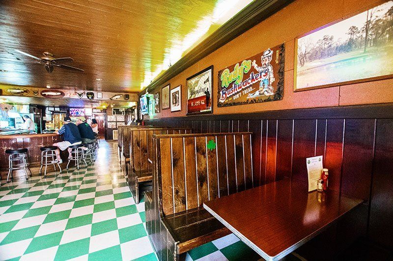 A restaurant with tables and chairs and a checkered floor.