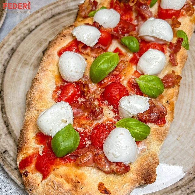 Il pizzaiolo Valentino Izzo che mostra una selezione di ingredienti di stagione