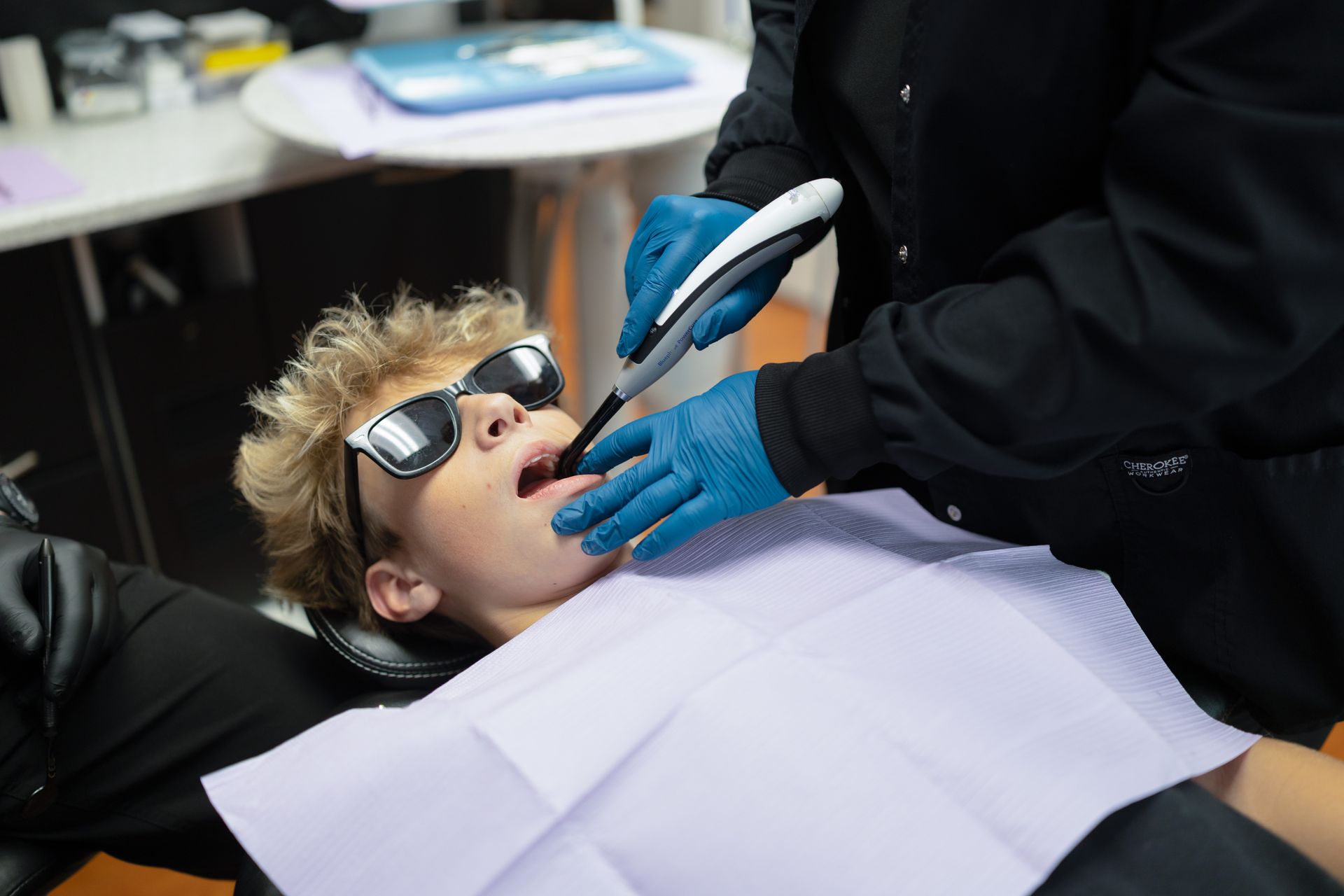 Young boy lying in dental chair while assistant uses the iTero Scanner