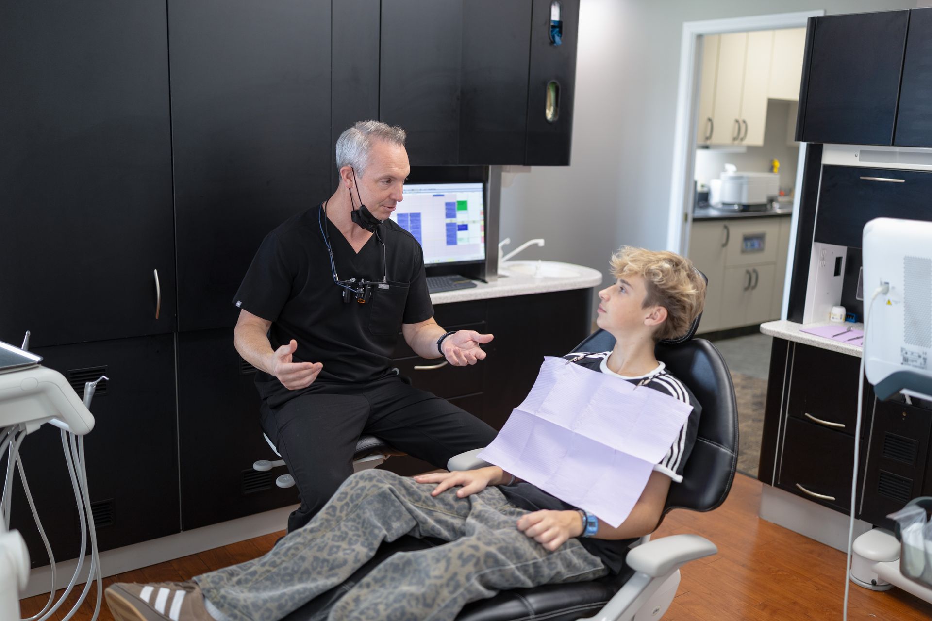 Dentist talking to young patient in the dental chair