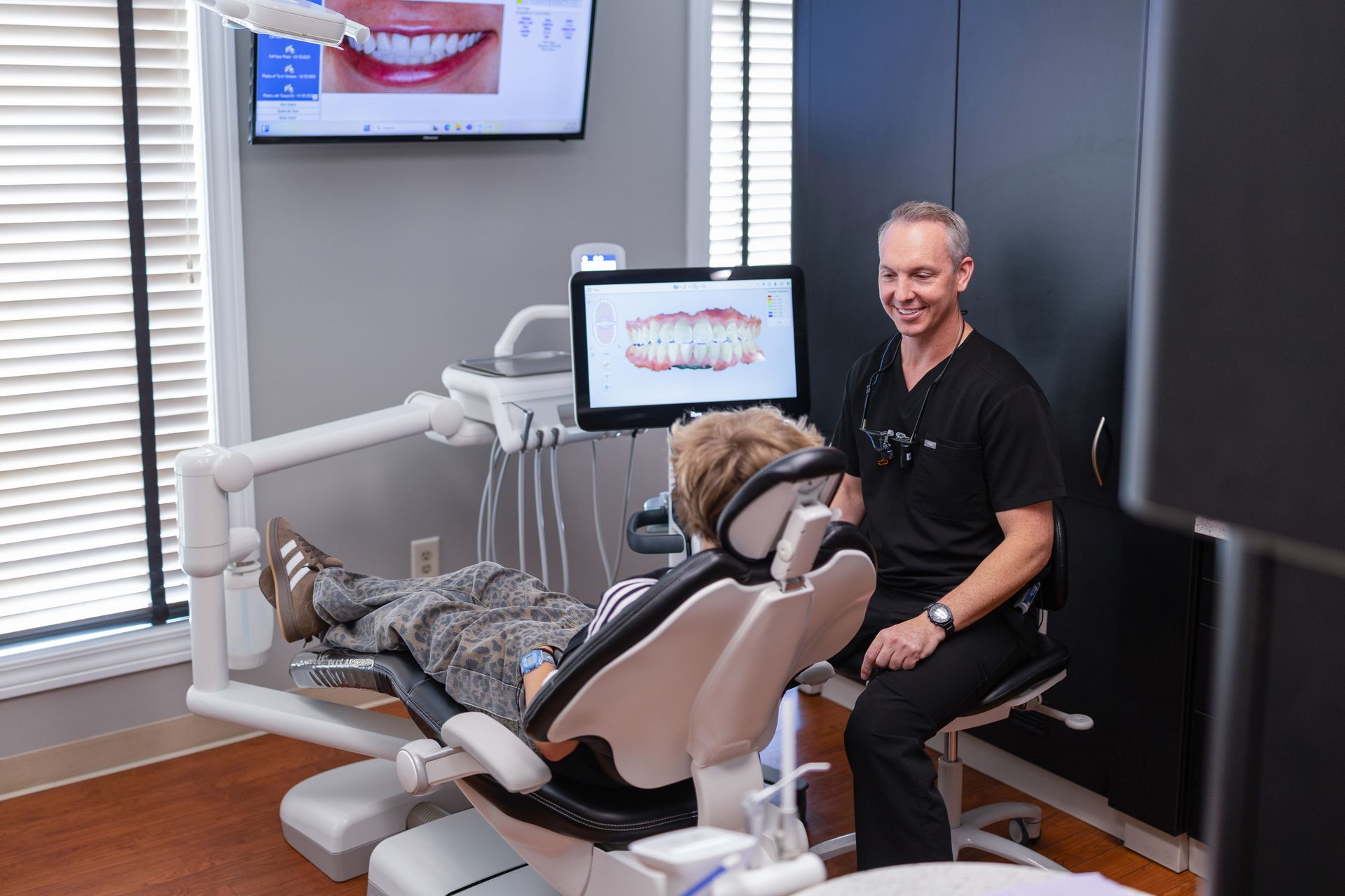 Dentist talks with young patient in the private room