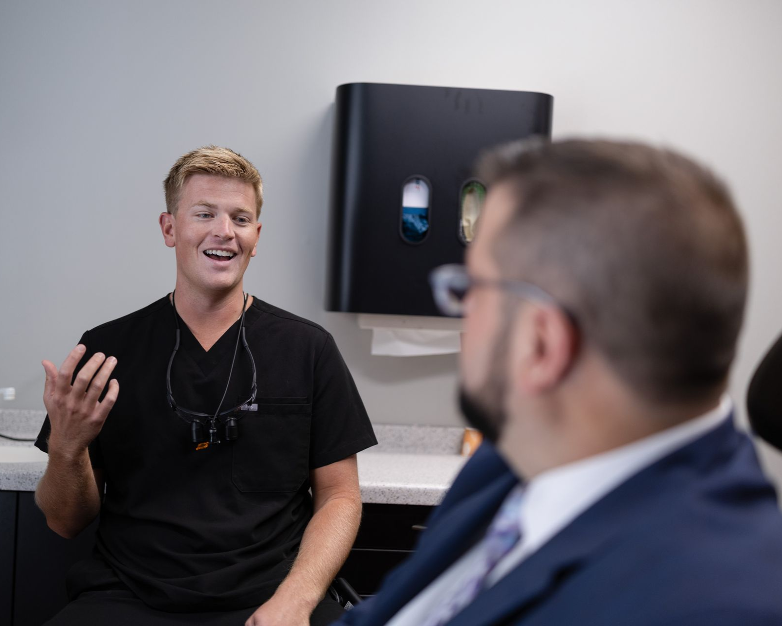 A middle aged male patient sitting in a chair listening to the dentist
