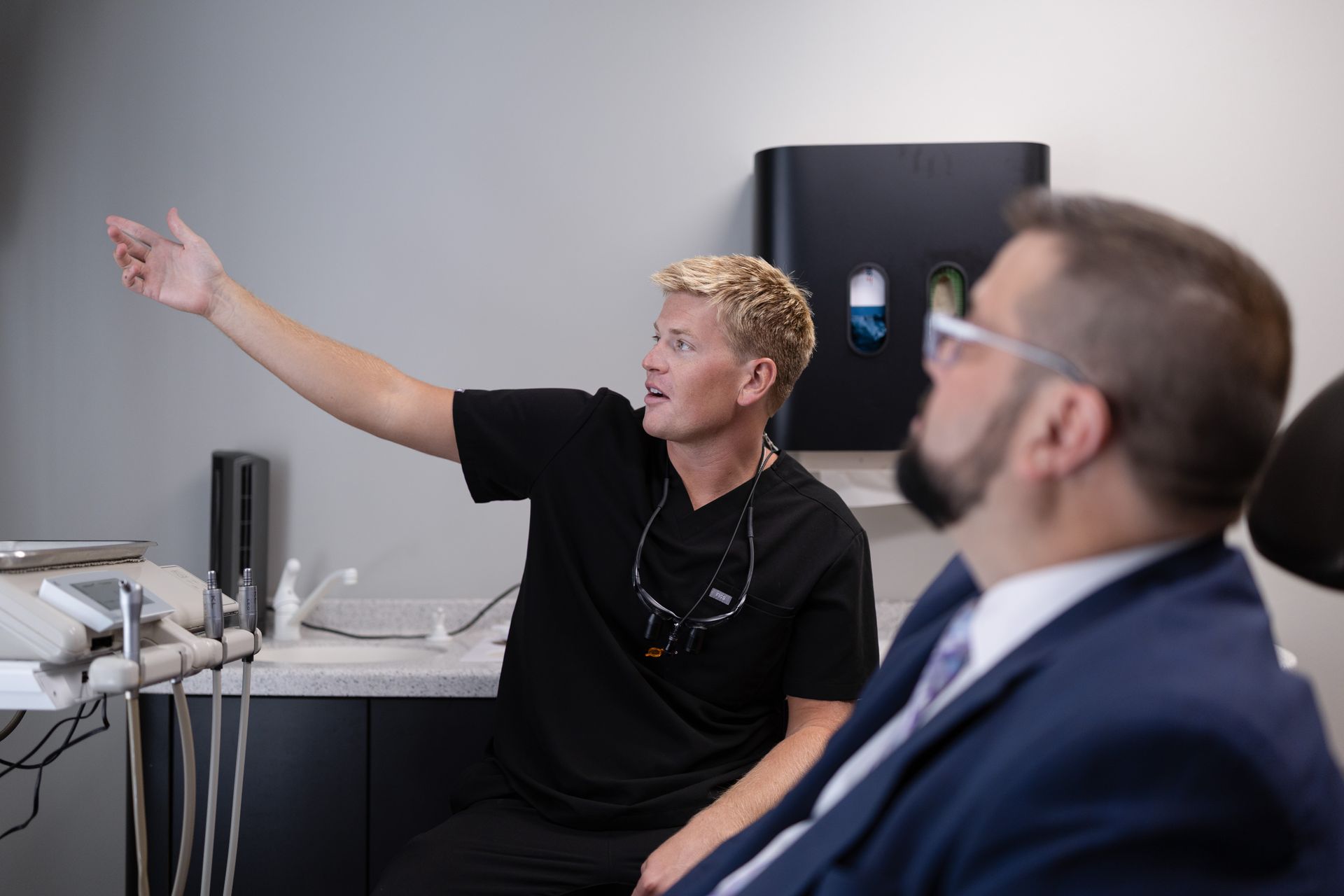 A dentist is instructing the patient sitting in the dental chair