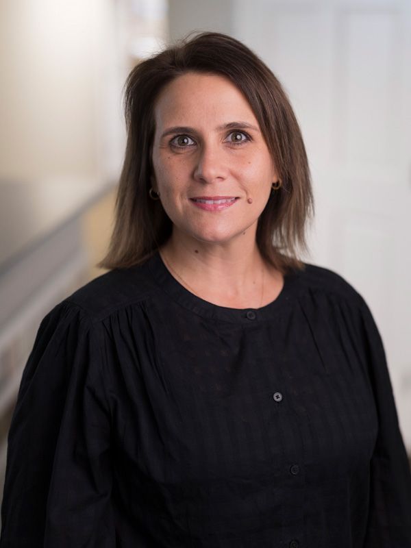 Woman smiling at camera in a dentist office wearing a black blouse