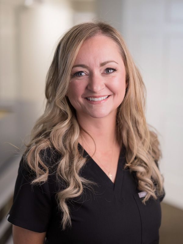 A blonde woman in black tshirt smiling at the camera