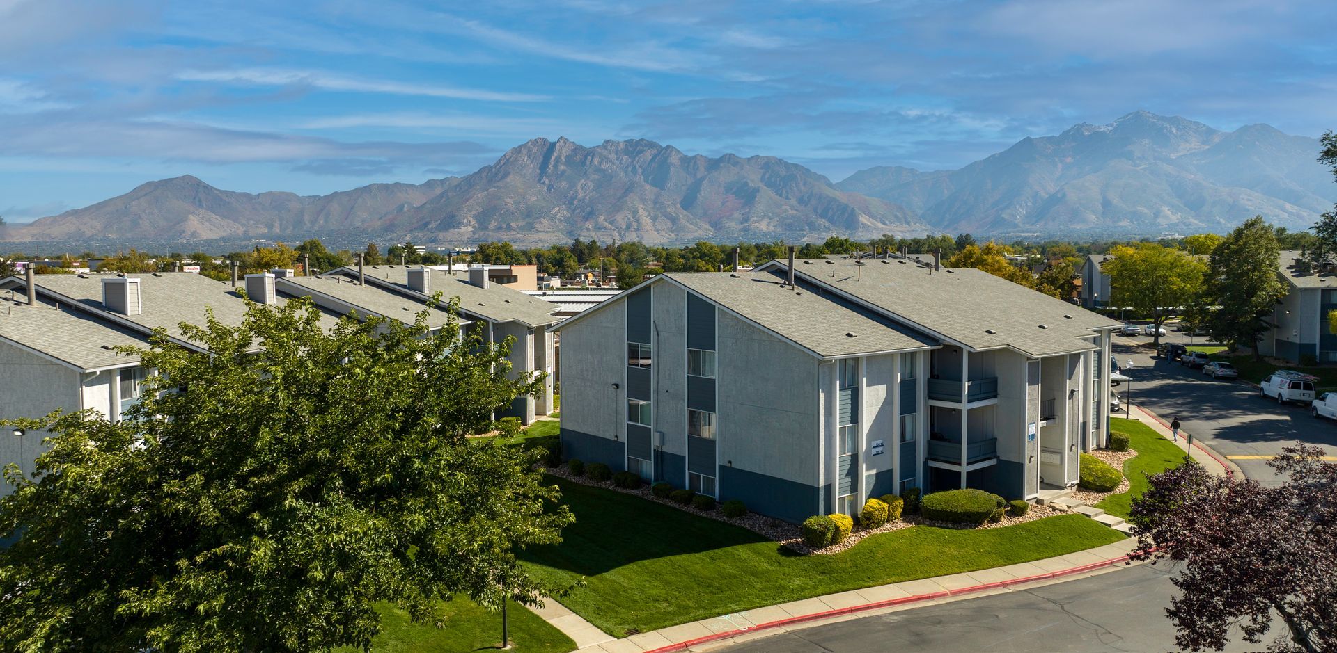 an aerial view of a apartment complex with mountains in the background .