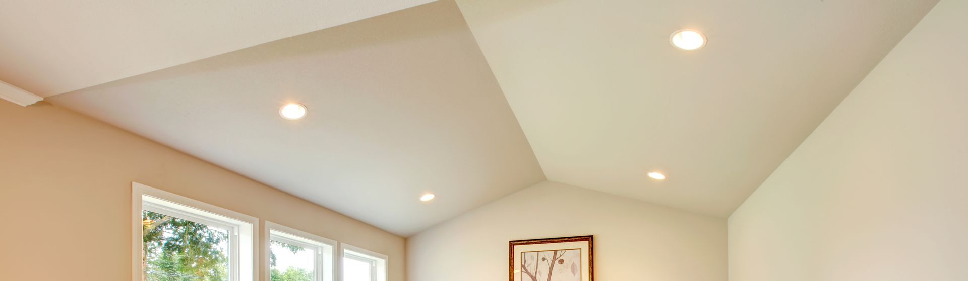 a room with a vaulted ceiling and a picture on the wall .