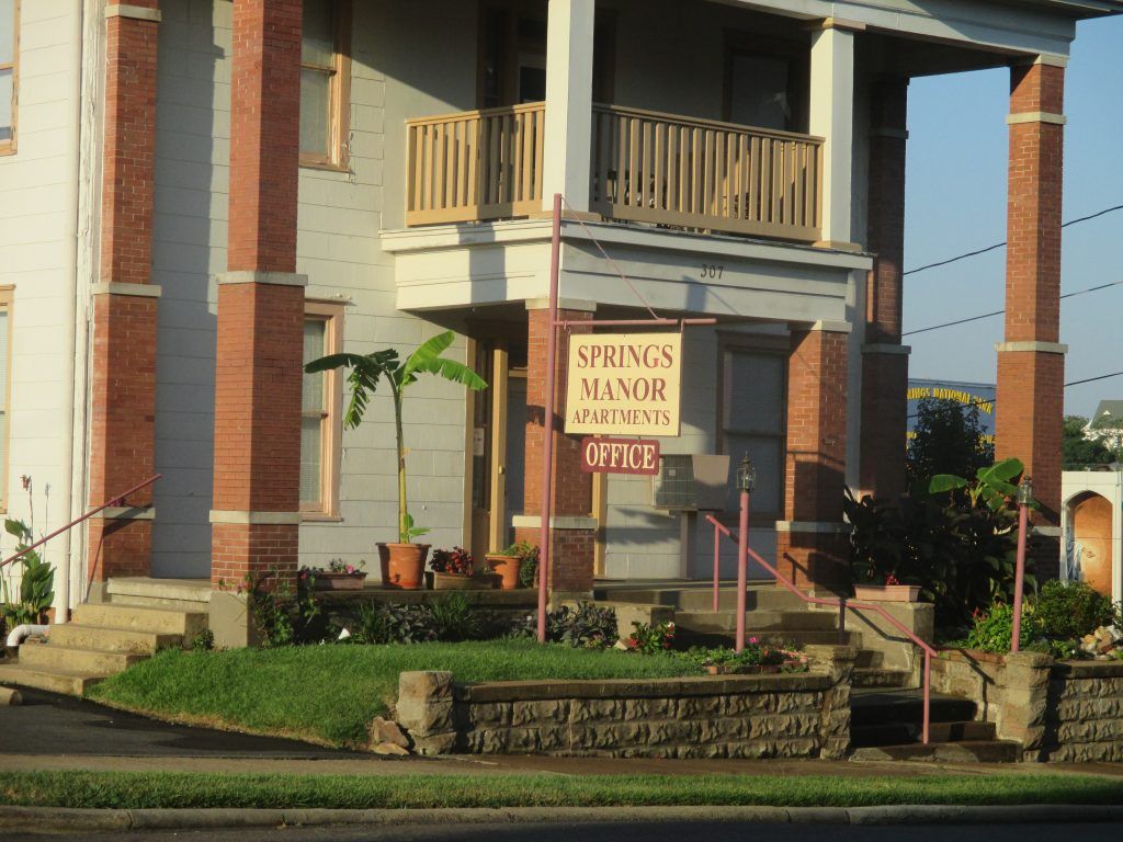 A large brick building with a sign that says springs manor