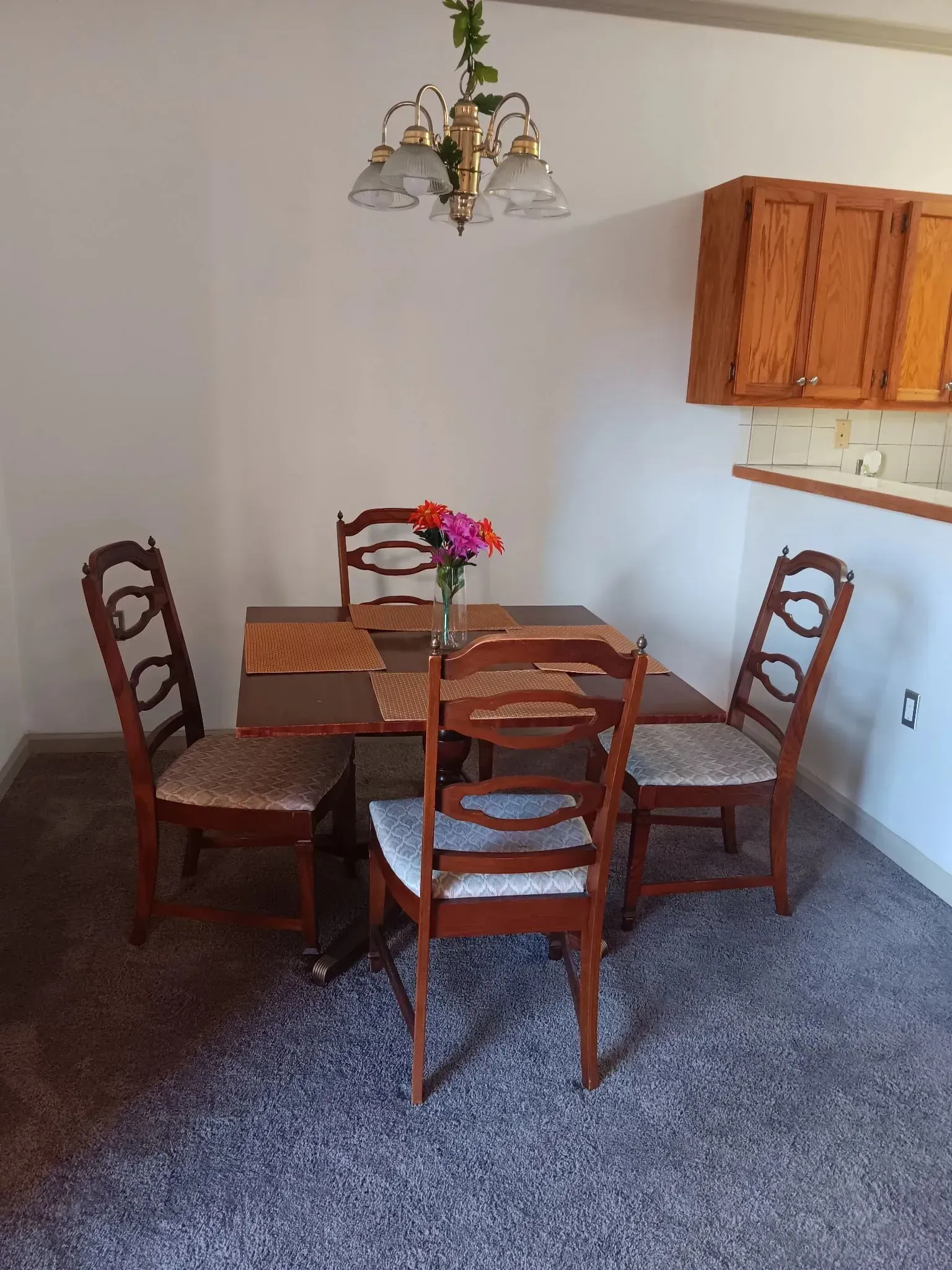 A dining room with a table and chairs and a chandelier