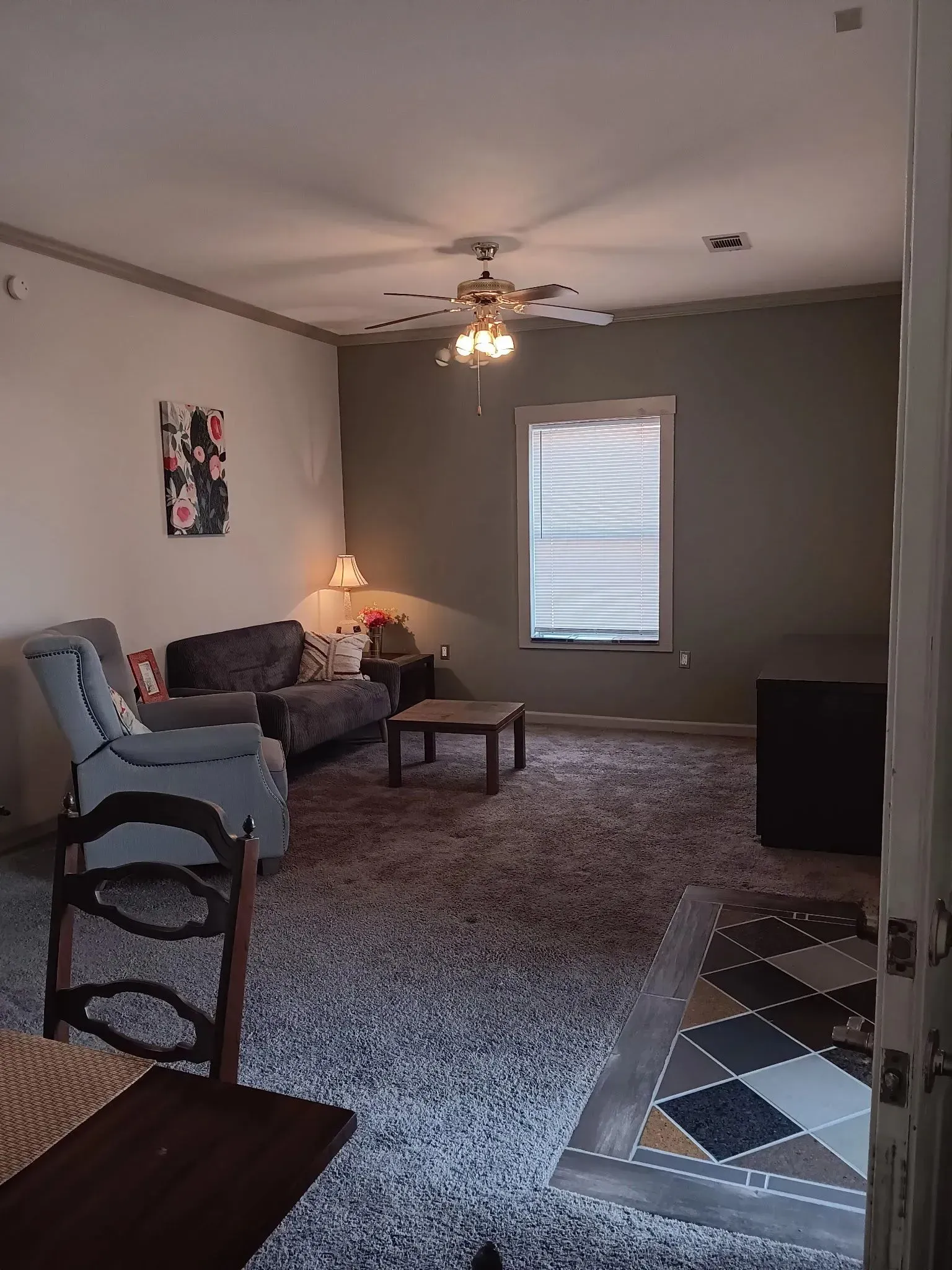 A living room filled with furniture and a ceiling fan.