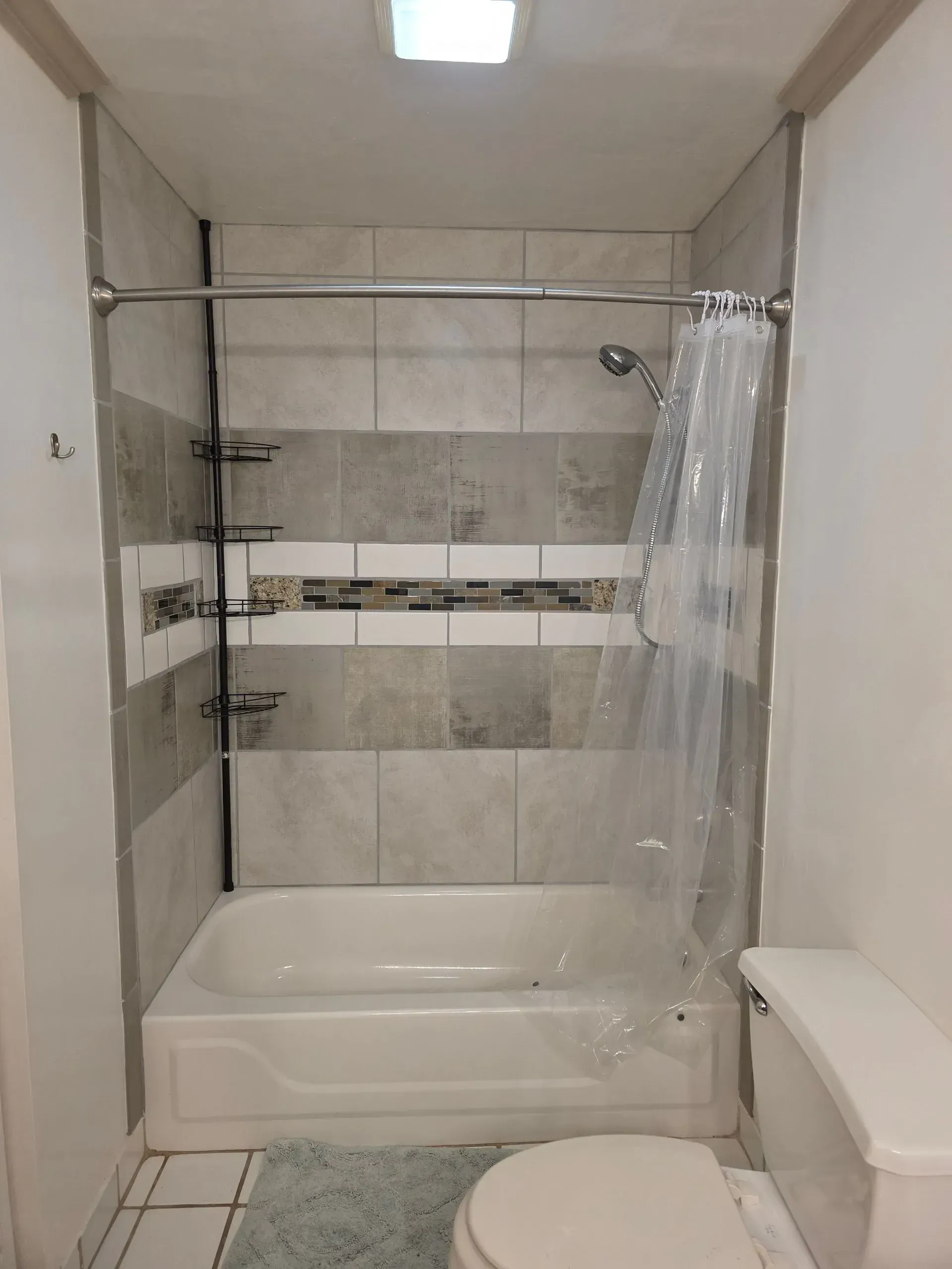 A bathroom with a tub , toilet and shower.