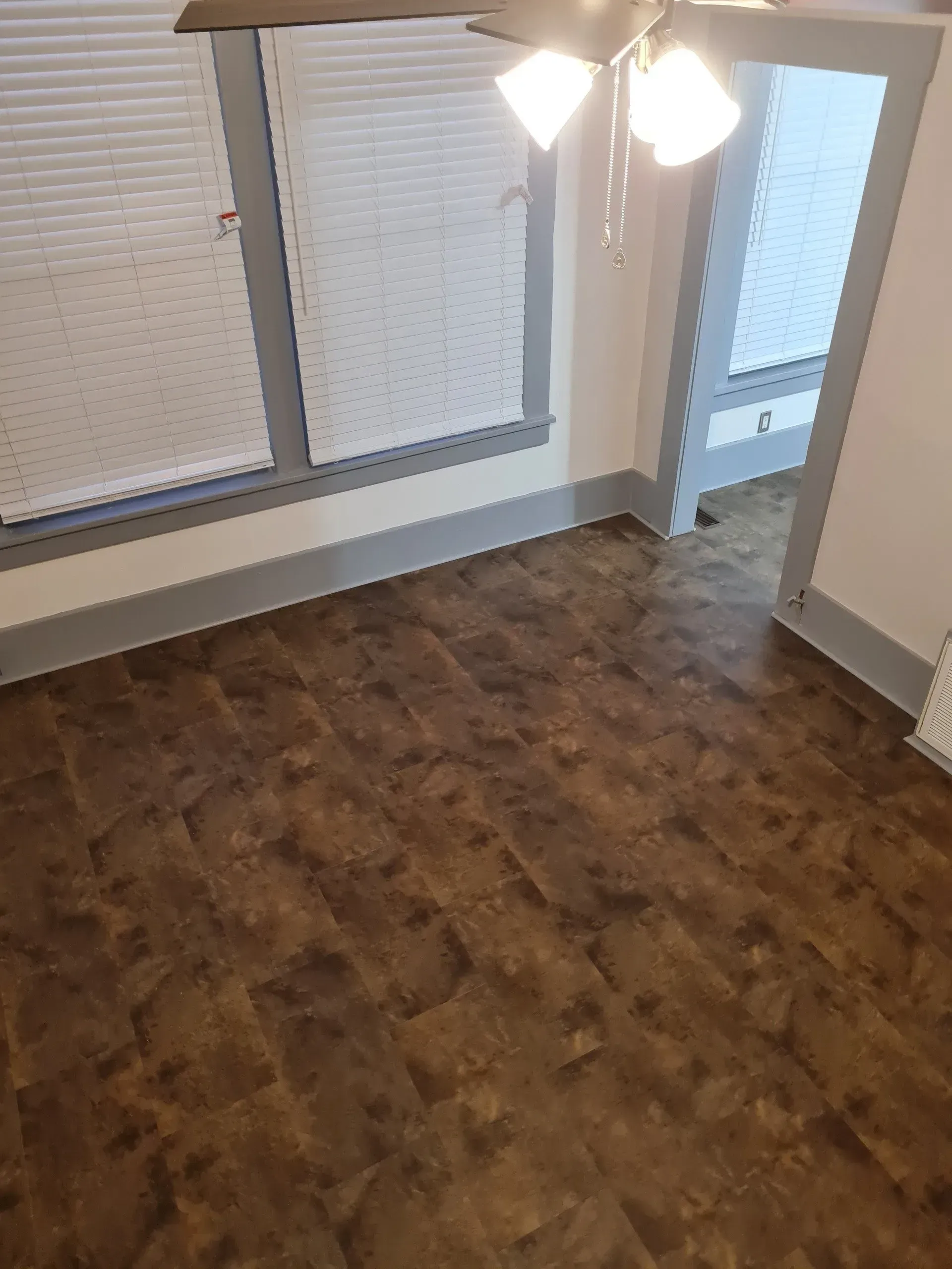 A room with a wooden floor and a ceiling fan.
