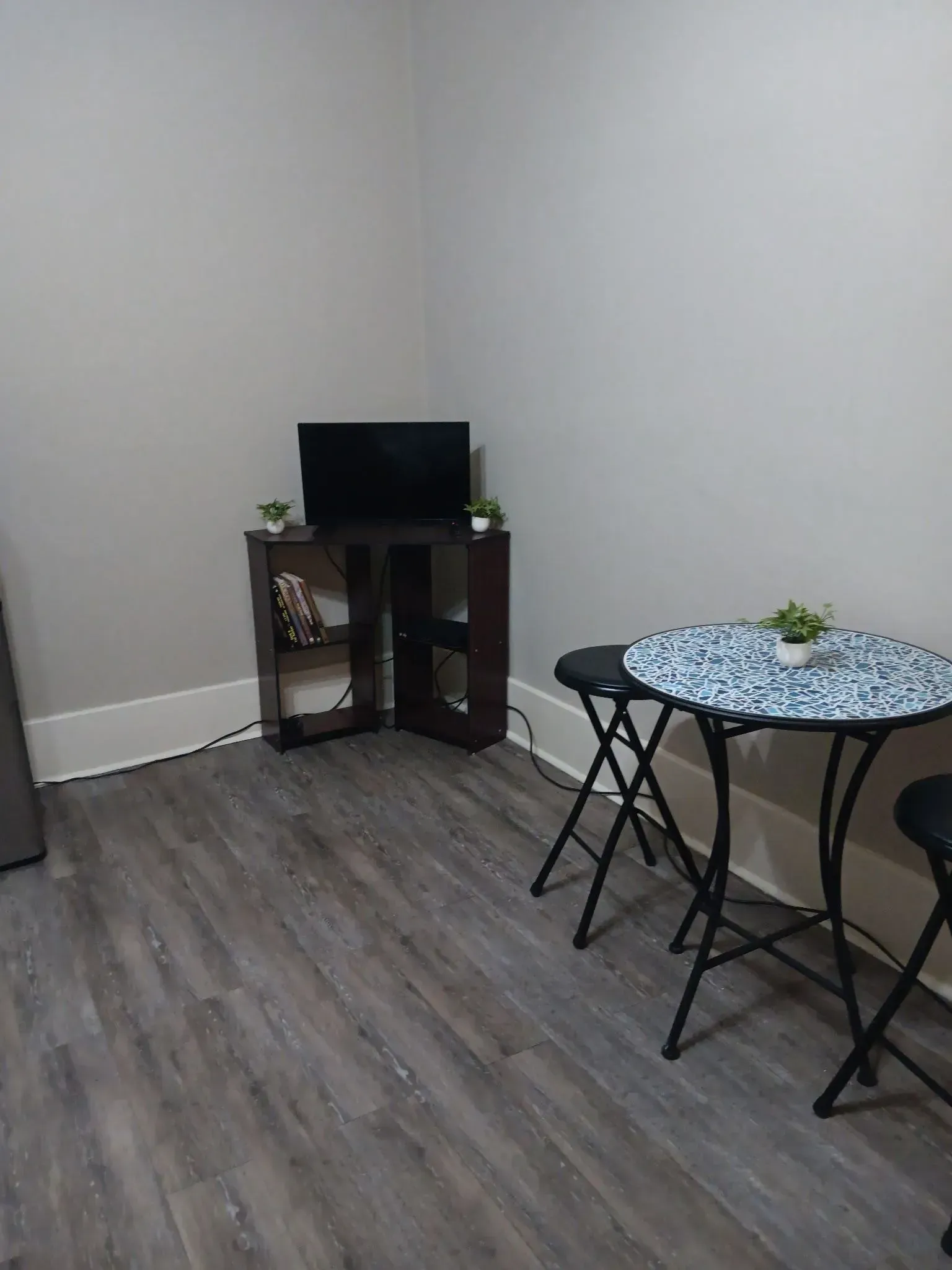 A living room with a table and chairs and a television.