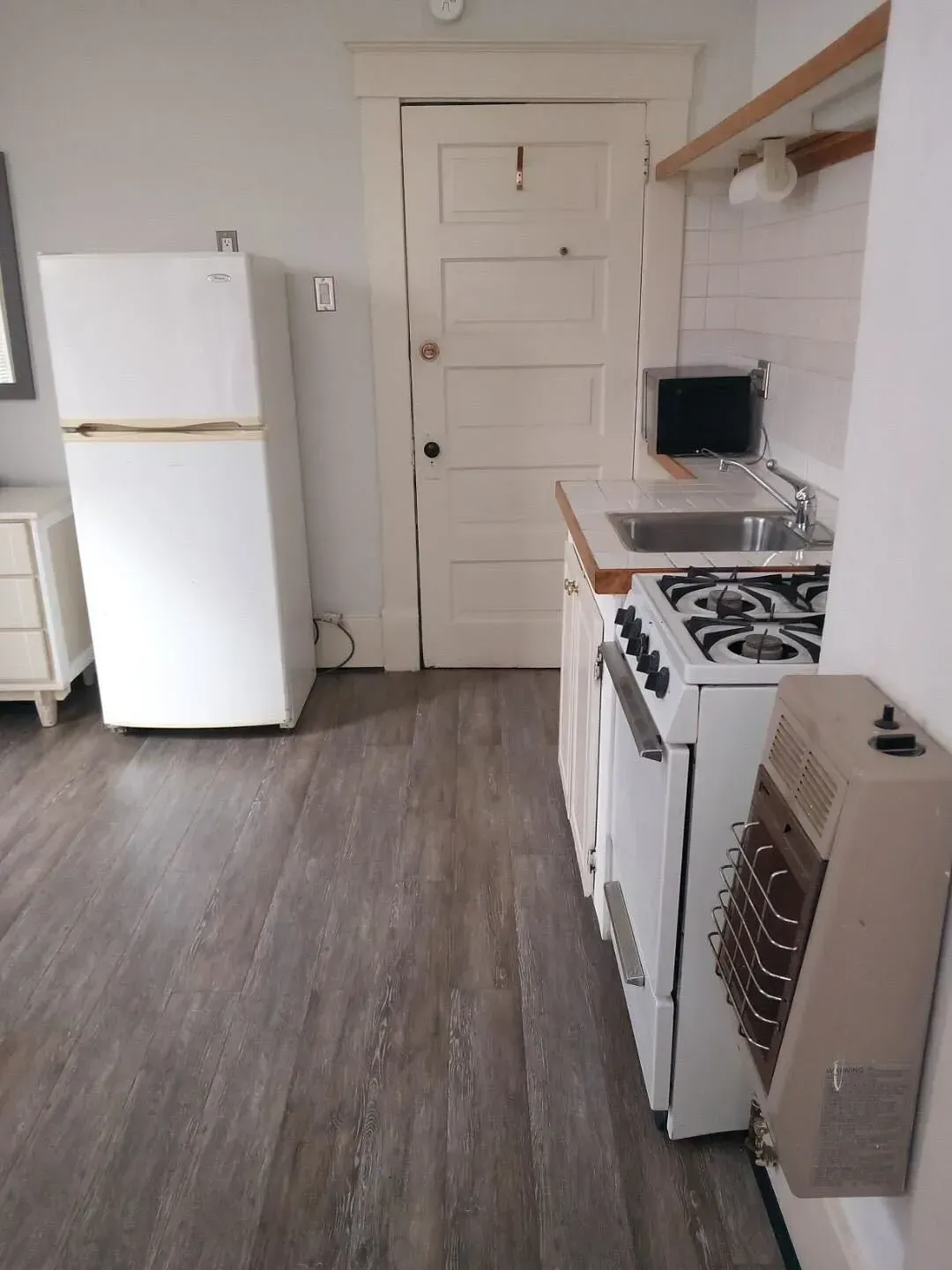 A kitchen with a refrigerator stove and sink