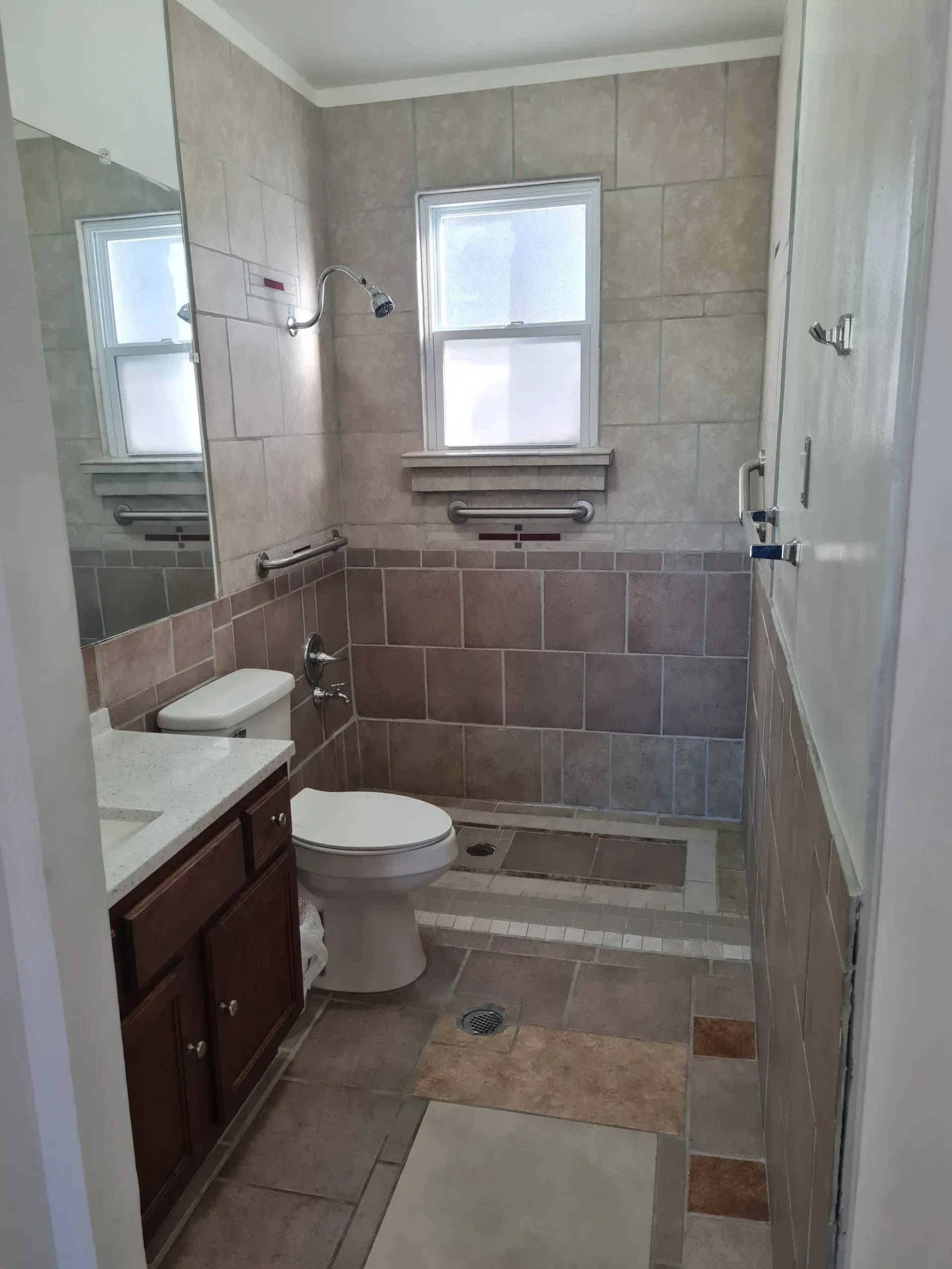 A bathroom with a toilet , sink , and shower.