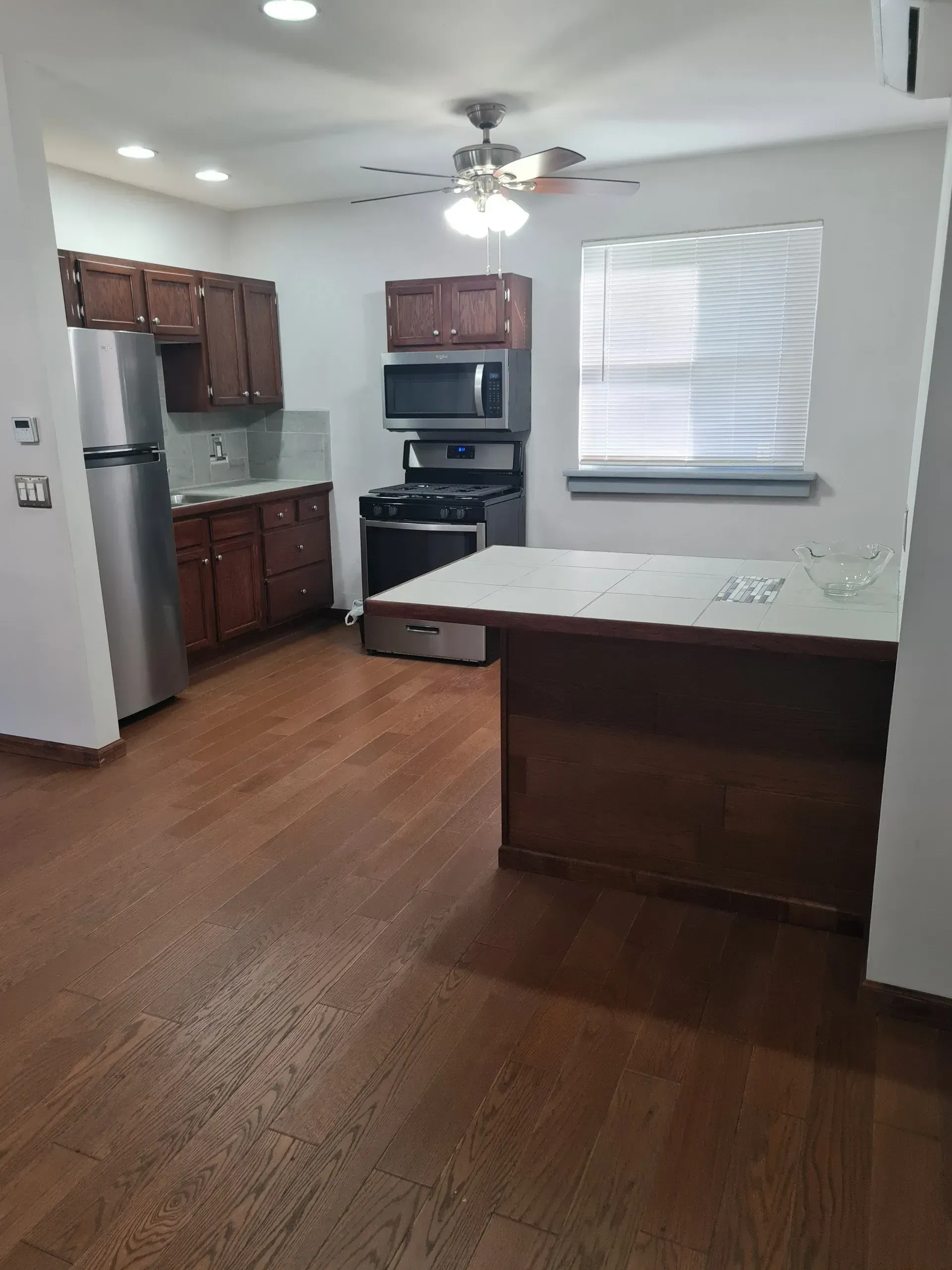 A kitchen with stainless steel appliances and wooden floors